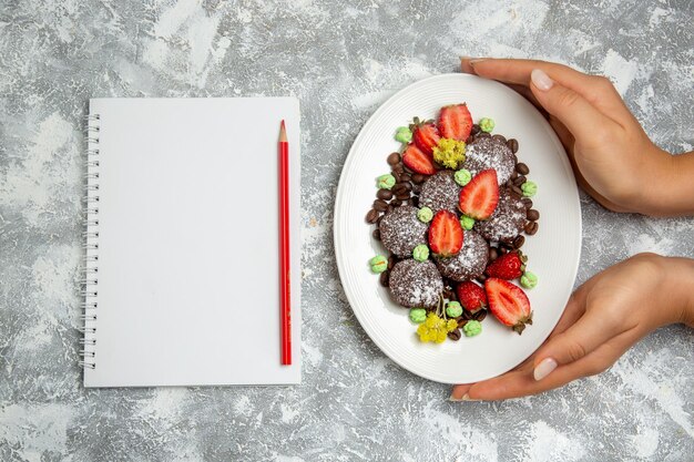 Vue De Dessus De Délicieux Gâteaux Au Chocolat Avec Des Fraises Rouges Fraîches Et Des Pépites De Chocolat Sur Un Biscuit Au Sol Blanc Gâteau Au Chocolat Sucré Cuire Des Biscuits