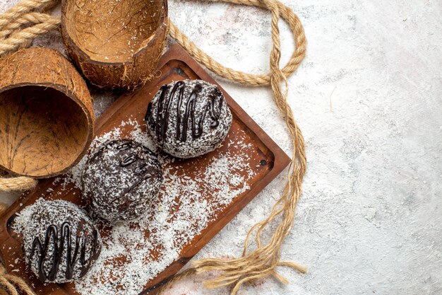 Vue de dessus de délicieux gâteaux au chocolat avec de la noix de coco sur une surface blanche