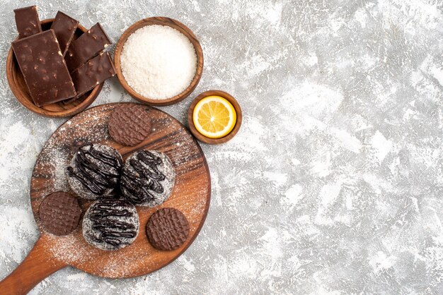 Vue de dessus de délicieux gâteaux aux boules de chocolat avec des biscuits sur une surface blanche