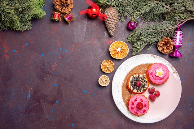 Vue de dessus de délicieux gâteaux aux fruits et à la crème sur fond noir