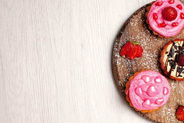 Vue de dessus de délicieux gâteaux aux fruits desserts crémeux avec des fruits sur fond blanc crème sucrée dessert biscuit gâteau tarte biscuit