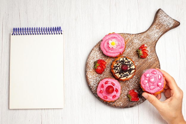 Vue de dessus de délicieux gâteaux aux fruits desserts crémeux avec des fruits sur fond blanc thé à la crème gâteau au dessert sucré cookie