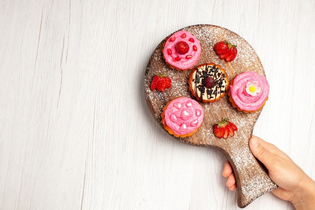 Photo gratuite vue de dessus de délicieux gâteaux aux fruits desserts crémeux avec des fruits sur fond blanc thé à la crème gâteau au dessert sucré cookie