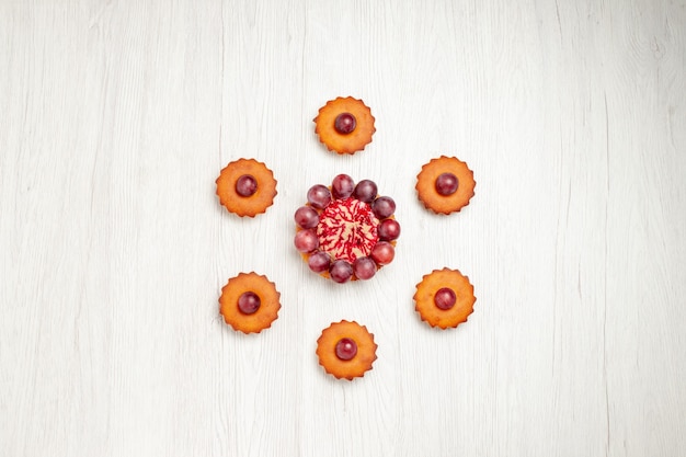 Vue de dessus de délicieux gâteaux aux raisins sur table blanche dessert biscuit tarte biscuit