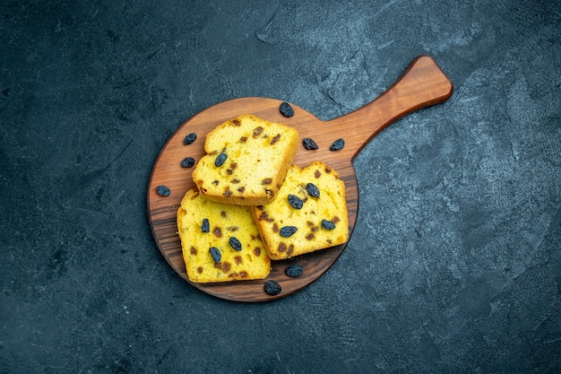 Vue de dessus de délicieux gâteaux aux raisins en tranches sur un espace bleu foncé