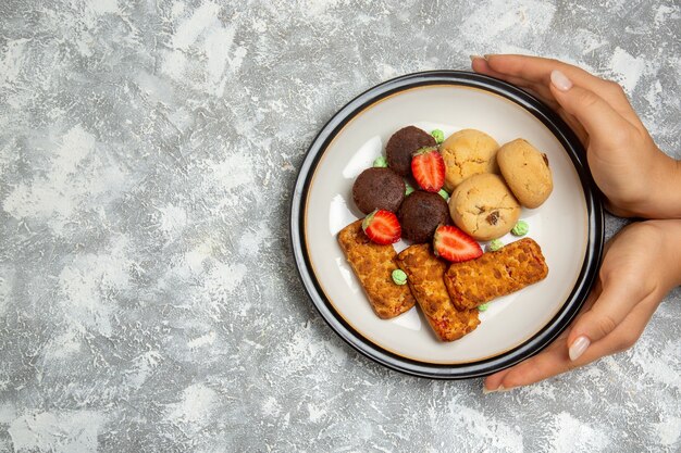 Photo gratuite vue de dessus de délicieux gâteaux avec des cookies et des fraises sur fond blanc biscuit gâteau au sucre tarte sucrée biscuit au thé