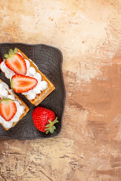 Vue de dessus de délicieux gâteaux crémeux aux fruits sur fond clair