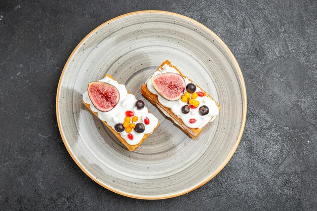 Vue de dessus de délicieux gâteaux gaufres avec des fruits sur le fond sombre