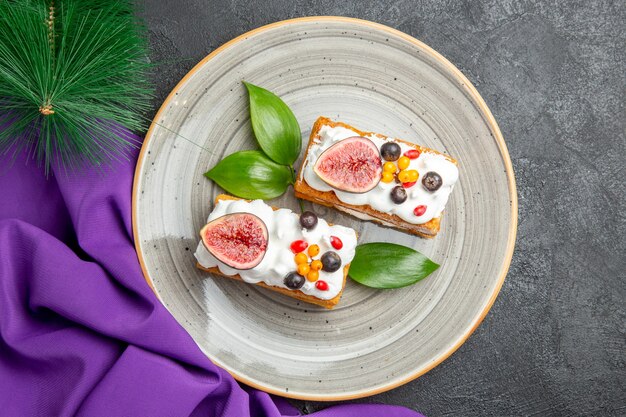 Vue de dessus de délicieux gâteaux gaufres avec des fruits sur le fond sombre