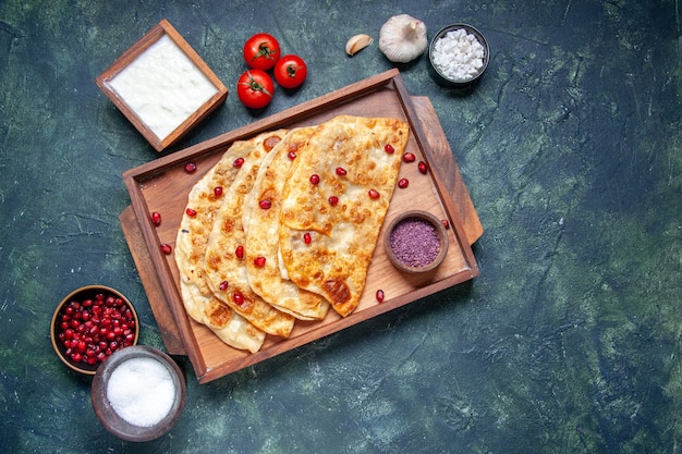 Vue de dessus de délicieux gutabs minces petits pains avec de la viande à l'intérieur du bureau sur fond sombre couleur pâte four tarte pâtisserie gâteau repas hotcake