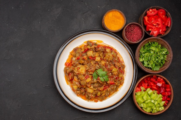 Vue de dessus de délicieux légumes cuits avec des assaisonnements sur fond gris repas salade santé sauce alimentaire