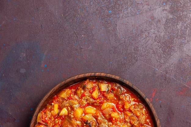 Vue de dessus de délicieux légumes cuits tranchés avec de la sauce sur un bureau sombre sauce alimentaire soupe repas légumes