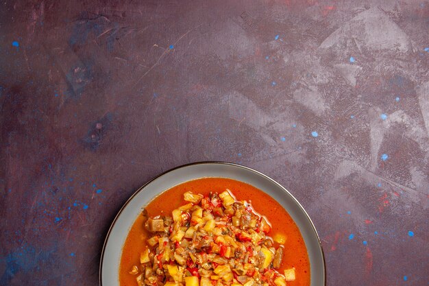 Vue de dessus de délicieux légumes cuits tranchés avec de la sauce sur fond sombre sauce soupe repas végétarien