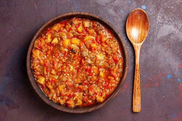 Vue de dessus de délicieux légumes cuits tranchés avec de la sauce sur fond sombre soupe sauce repas repas végétarien