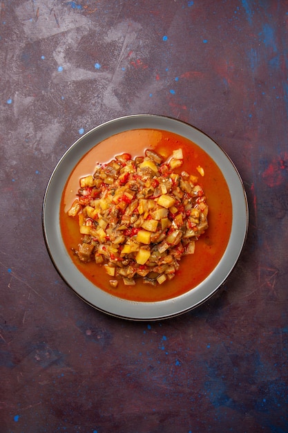 Photo gratuite vue de dessus de délicieux légumes cuits tranchés avec de la sauce sur une surface sombre sauce soupe alimentaire repas légume
