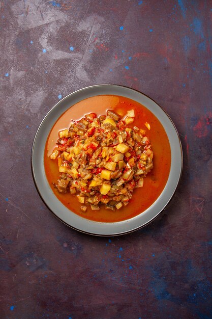 Vue de dessus de délicieux légumes cuits tranchés avec de la sauce sur une surface sombre sauce soupe alimentaire repas légume