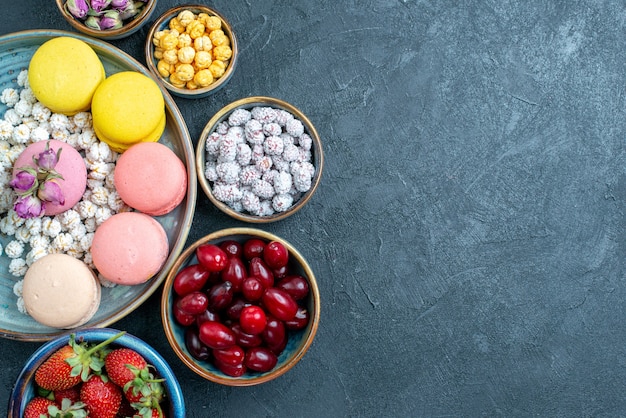 Vue de dessus délicieux macarons français avec fruits sur gris