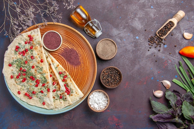 Photo gratuite vue de dessus de délicieux morceaux de pâte cuits qutabs avec des légumes verts sur une surface sombre calories gras plat cuisson pâte repas