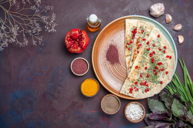 Vue de dessus de délicieux morceaux de pâte cuits qutabs avec des légumes verts sur une surface violet foncé