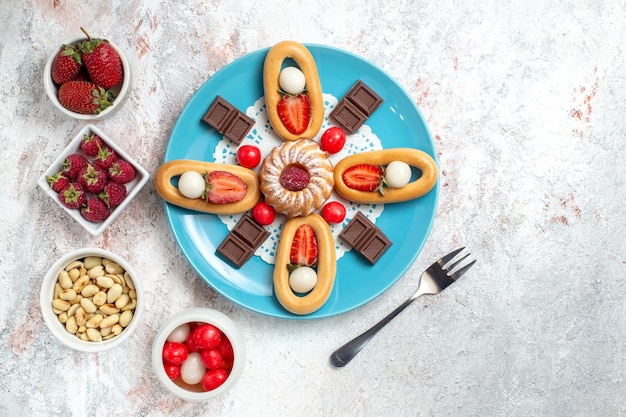 Vue de dessus délicieux petit gâteau avec des barres de chocolat et des craquelins sucrés sur fond blanc craquelins biscuits sucrés tarte thé