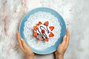 Photo gratuite vue de dessus délicieux petit gâteau à la crème et fraises sur blanc
