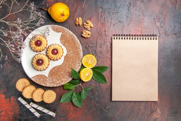 Vue de dessus délicieux petits biscuits aux fruits sur la table sombre gâteau au sucre biscuit sucré