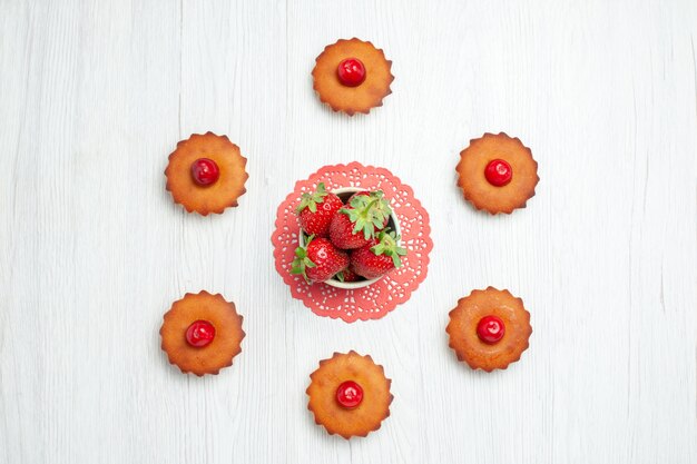 Vue de dessus de délicieux petits gâteaux sur un bureau blanc