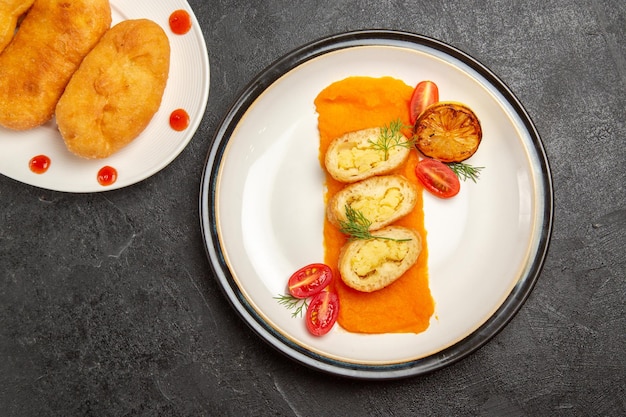 Vue de dessus de délicieux petits pains aux pommes de terre avec des tranches de tarte aux pommes de terre et de la citrouille sur fond sombre