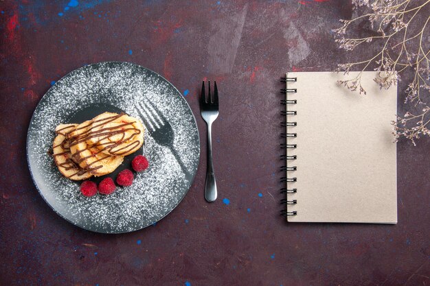 Vue de dessus de délicieux petits pains sucrés en tranches de gâteau pour le thé à l'intérieur de la plaque sur le noir