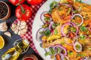 Photo gratuite vue de dessus d'un délicieux plat de poulet frit avec diverses épices et aliments tomates avec tiges poivre oignons ails bouteille d'huile tombée sur fond de couleur sombre