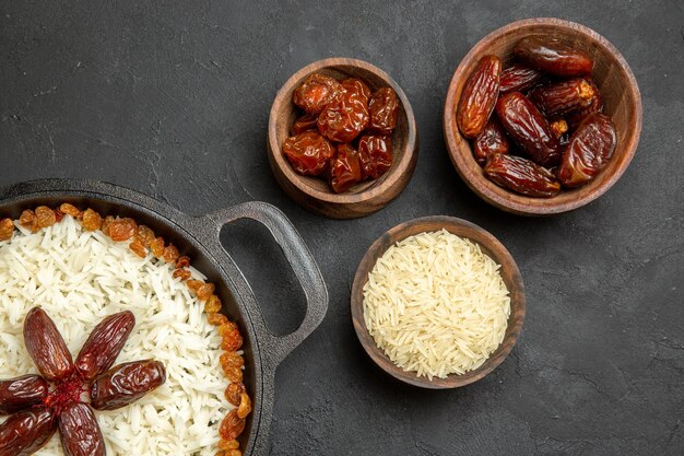 Vue de dessus délicieux plat de riz cuit plov avec différents raisins secs sur fond sombre plat de riz aux raisins secs alimentaire dîner huile