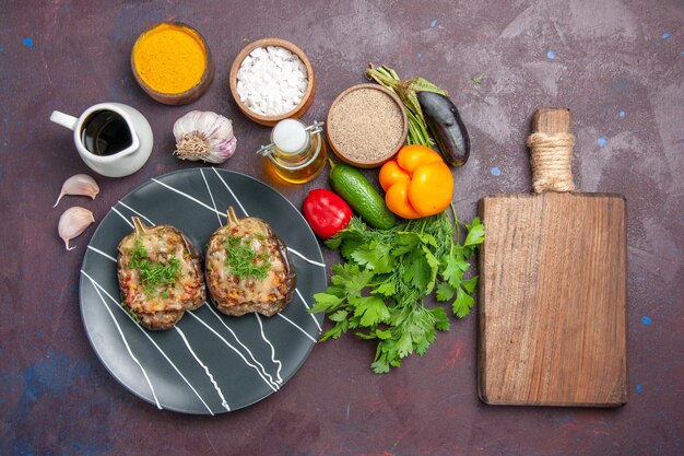 Vue de dessus de délicieux poivrons cuits repas de légumes avec de la viande hachée et des légumes verts sur le plat de fond sombre dîner repas cuire couleur calorie