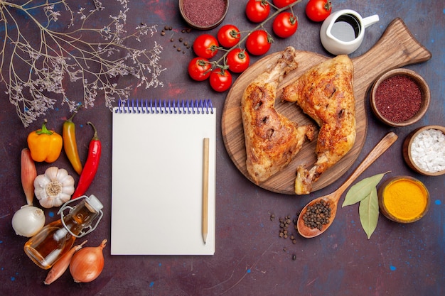 Vue de dessus délicieux poulet frit avec assaisonnements et légumes sur l'espace sombre