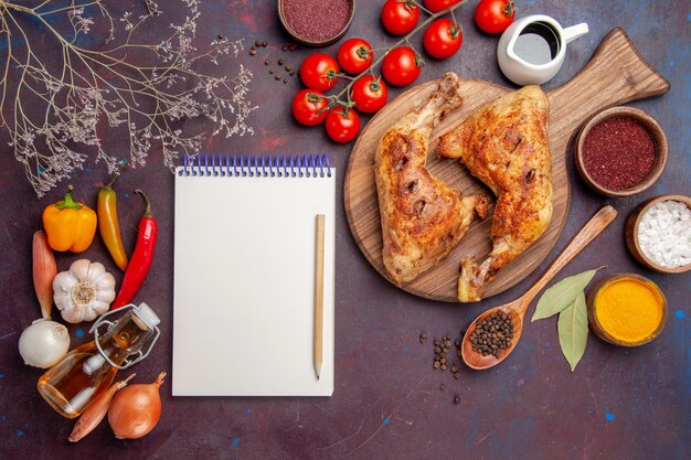 Vue de dessus délicieux poulet frit avec assaisonnements et légumes sur l'espace sombre