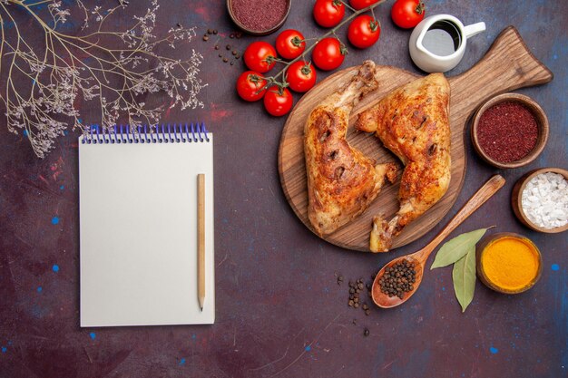 Vue de dessus délicieux poulet frit avec assaisonnements et légumes sur plat de viande de poulet au sol sombre