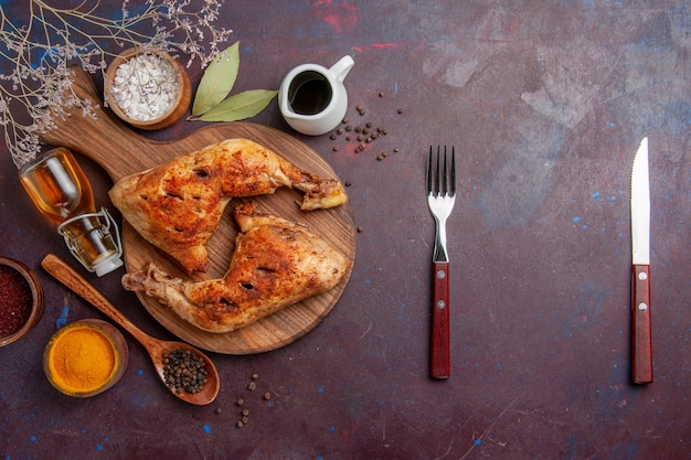 Vue de dessus délicieux poulet frit avec différents assaisonnements sur un bureau sombre