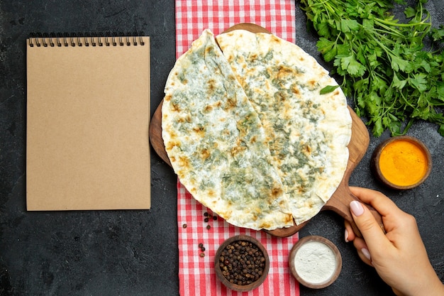 Vue de dessus de délicieux qutabs de tranches de pâte cuites avec des verts à l'intérieur sur l'espace gris