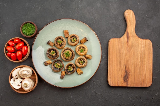 Photo gratuite vue de dessus délicieux repas de champignons avec des légumes verts frais et des tomates sur un plat de bureau sombre dîner repas cuisson champignon