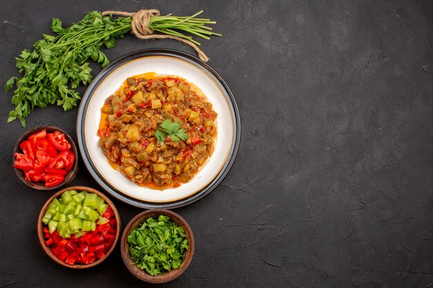 Vue de dessus délicieux repas de légumes plat cuit en tranches à l'intérieur de la plaque sur fond gris repas dîner nourriture sauce soupe légumes