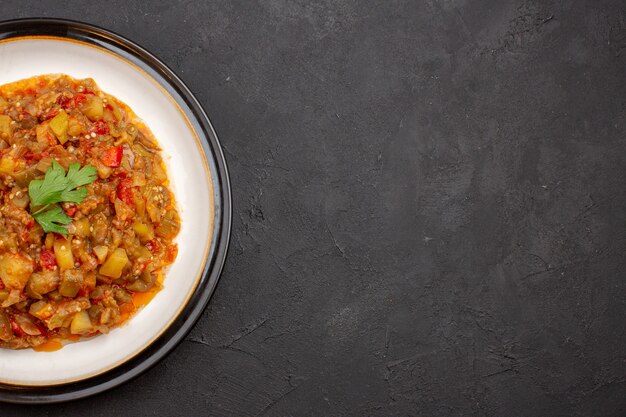 Vue de dessus délicieux repas de légumes plat cuit en tranches à l'intérieur de la plaque sur le fond gris repas nourriture sauce soupe dîner légume