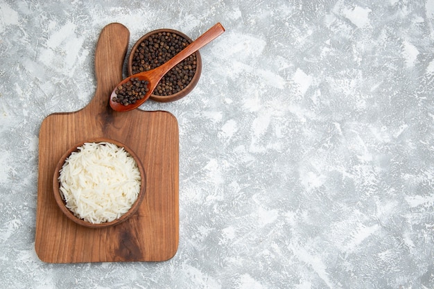 Vue de dessus délicieux riz cuit avec du poivre sur blanc