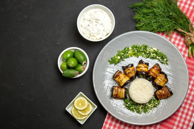 Vue de dessus de délicieux rouleaux d'aubergine repas cuit avec du riz sur fond noir