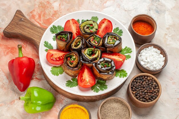 Vue de dessus de délicieux rouleaux d'aubergines avec des tomates et différents assaisonnements