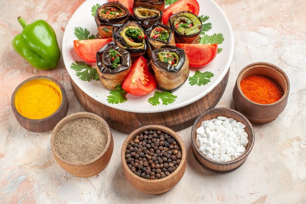 Vue de dessus de délicieux rouleaux d'aubergines avec des tomates et différents assaisonnements