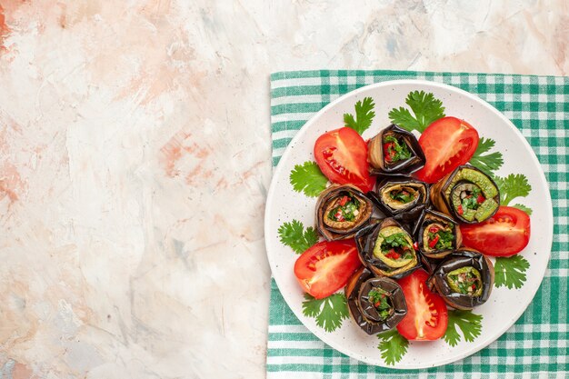 Vue de dessus de délicieux rouleaux d'aubergines avec tomates et légumes verts