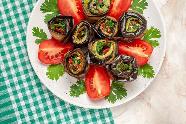 Vue de dessus de délicieux rouleaux d'aubergines avec tomates et légumes verts