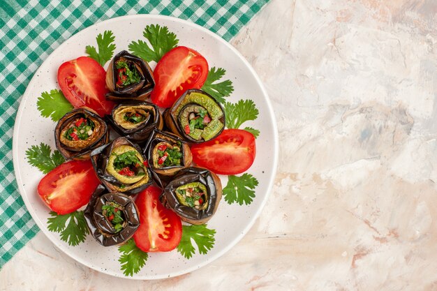 Vue de dessus de délicieux rouleaux d'aubergines avec tomates et légumes verts