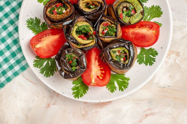 Vue de dessus de délicieux rouleaux d'aubergines avec tomates et légumes verts