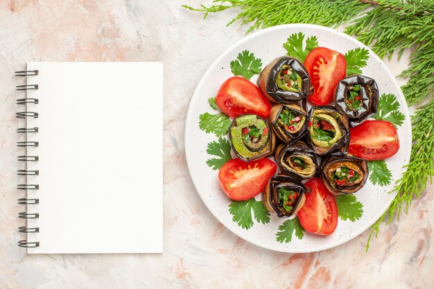 Vue de dessus de délicieux rouleaux d'aubergines avec des verts et des tomates