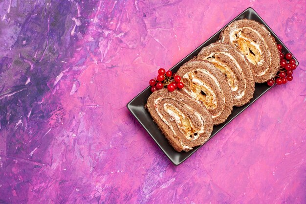 Vue de dessus délicieux rouleaux de biscuits aux fruits sur fond rose